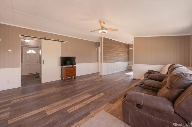 a living room with furniture and a ceiling fan