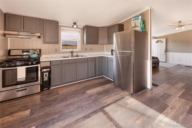 a kitchen with stainless steel appliances granite countertop a refrigerator stove and sink