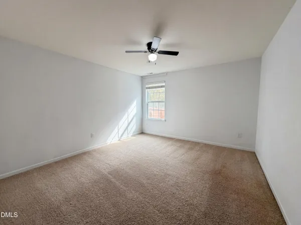 an empty room with a window and a ceiling fan