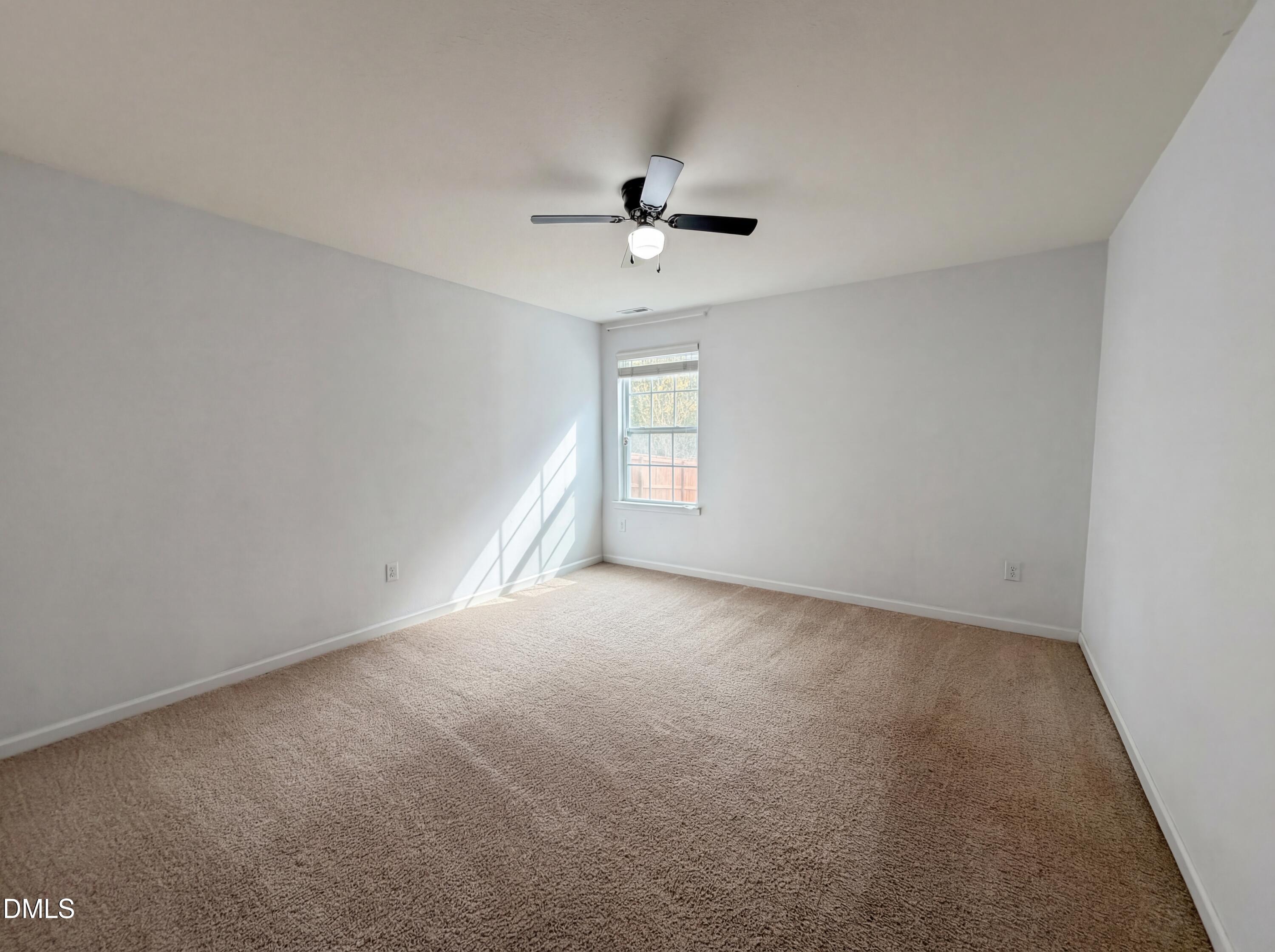 574 Botanical Court Bunnlevel, NC 28323 - Photo 13 of 20 an empty room with a window and a ceiling fan