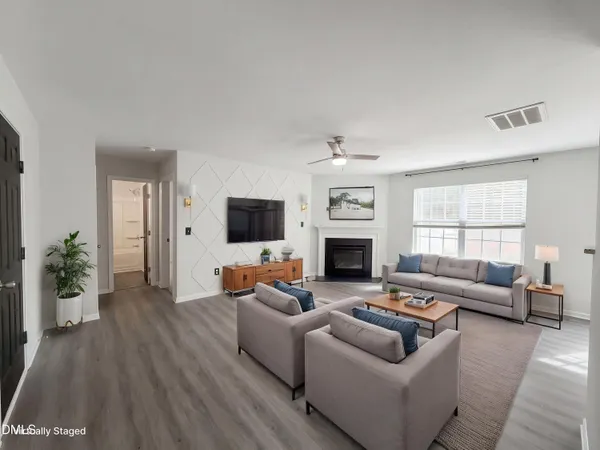 a living room with furniture a flat screen tv and a fireplace