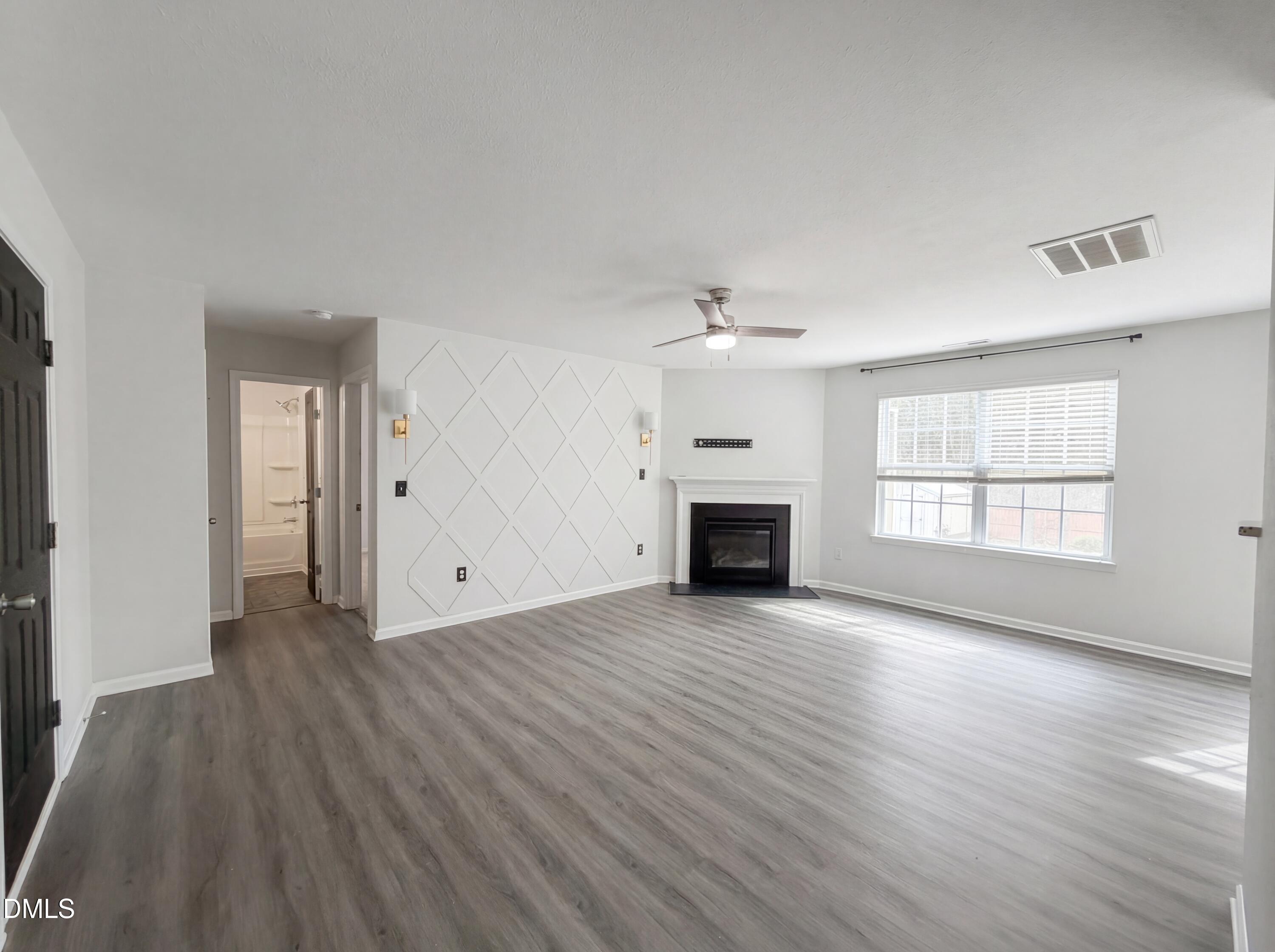 574 Botanical Court Bunnlevel, NC 28323 - Photo 3 of 20 an empty room with wooden floor fireplace and windows