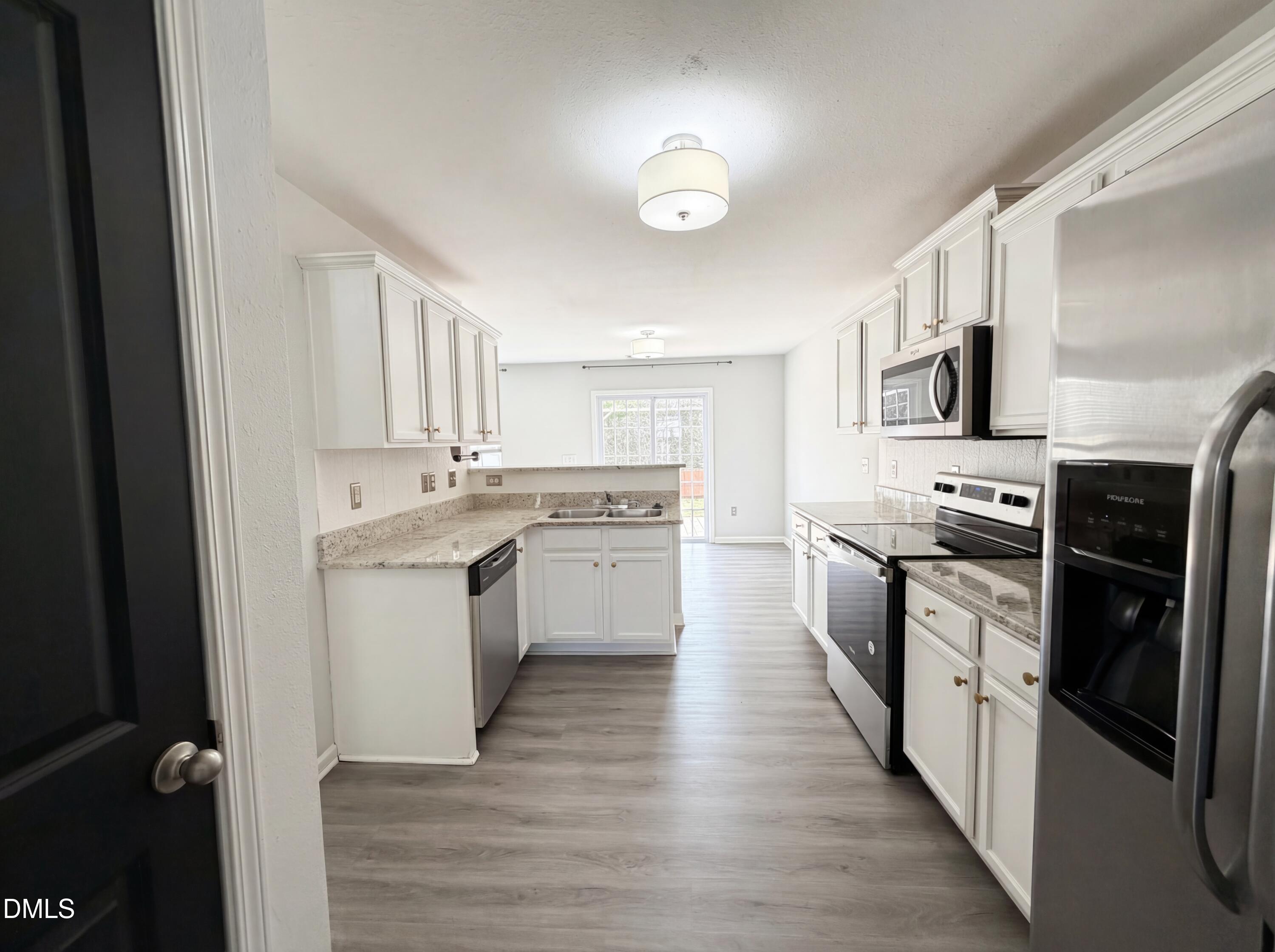 574 Botanical Court Bunnlevel, NC 28323 - Photo 5 of 20 a kitchen with white cabinets and appliances