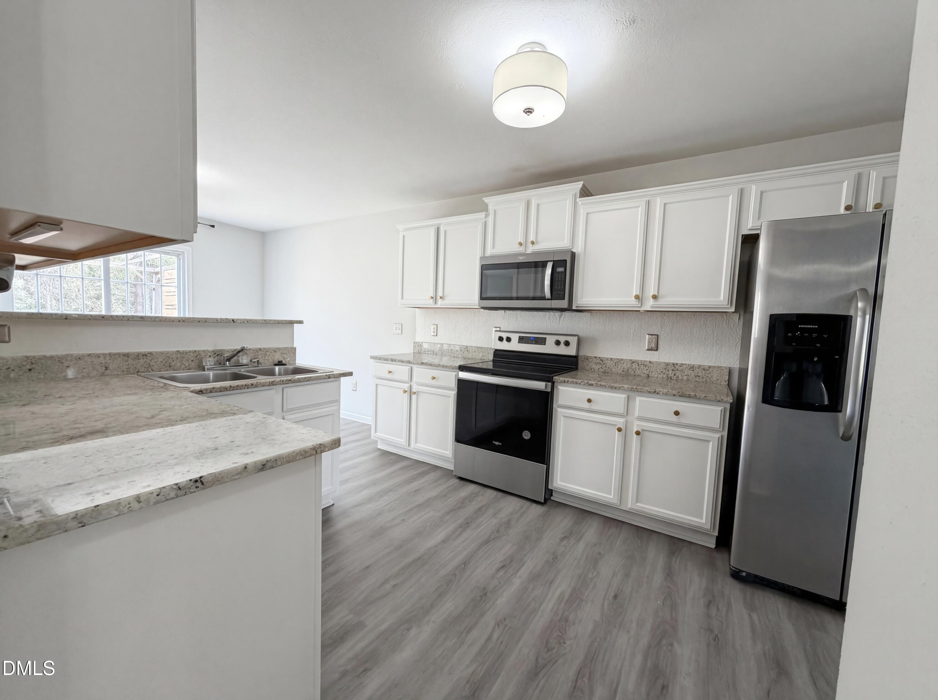 574 Botanical Court Bunnlevel, NC 28323 - Photo 6 of 20 a kitchen with kitchen island granite countertop a sink cabinets and stainless steel appliances