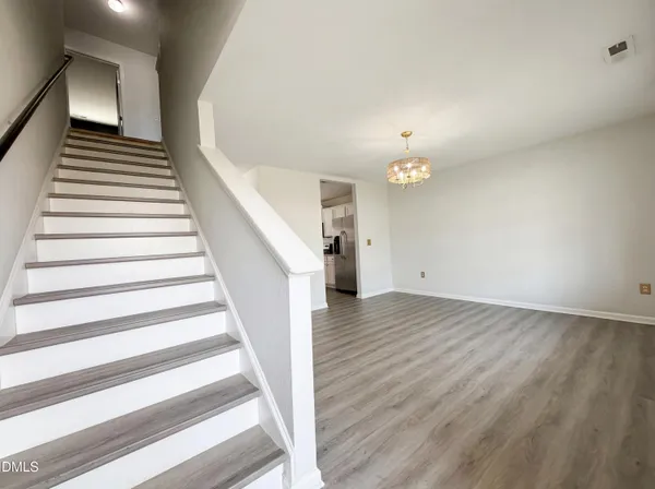 a view of a hallway with wooden floor and staircase