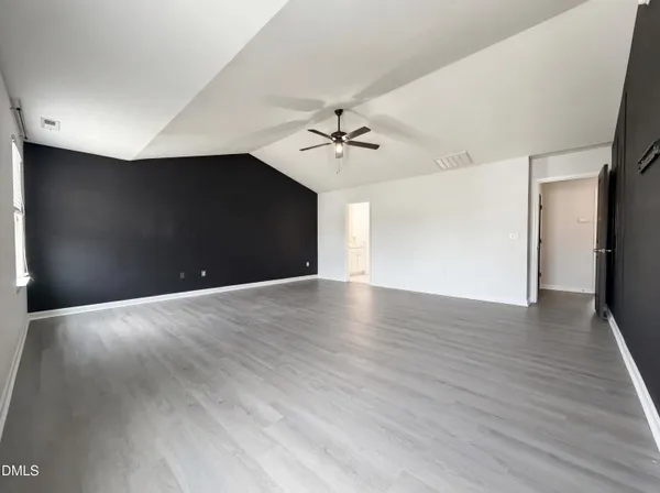 a view of a livingroom with a ceiling fan wooden floor and a ceiling fan