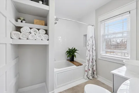 a white bath tub sitting next to a white toilet