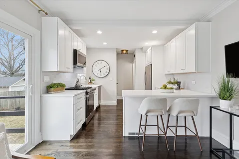 a kitchen with a table chairs microwave and cabinets