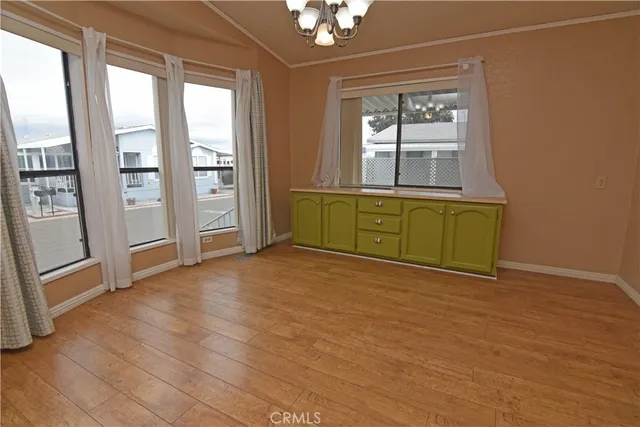 an empty room with windows cabinet and front door