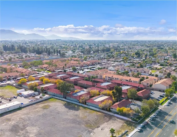an aerial view of residential houses with outdoor space and trees