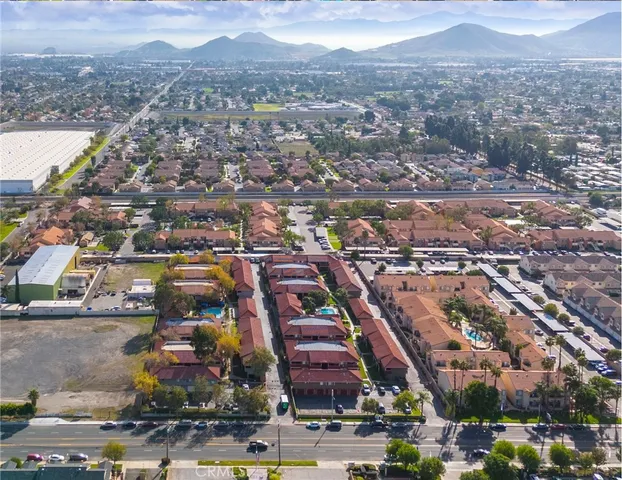 a view of a white house with a large tree