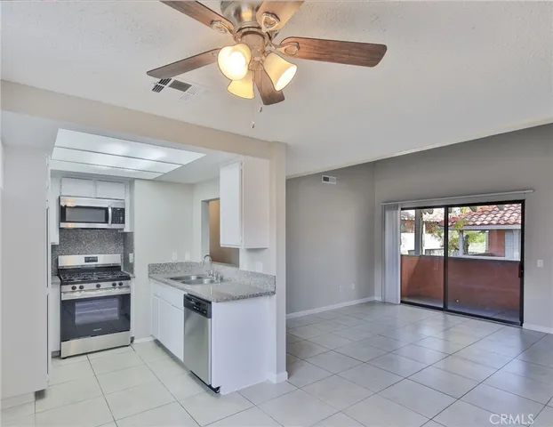 a bathroom with a granite countertop sink mirror vanity and toilet