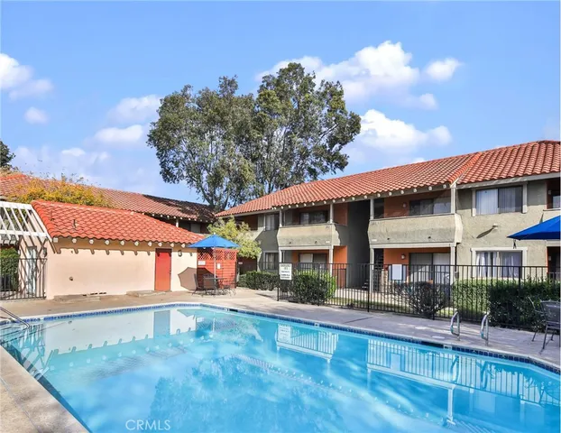 a view of a patio with couches and table and chairs with wooden floor and fence