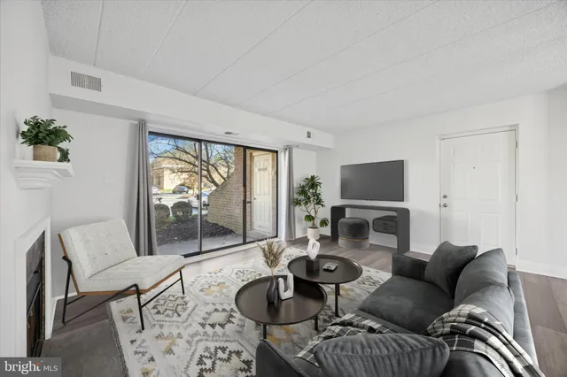 a living room with furniture a flat screen tv and a large window