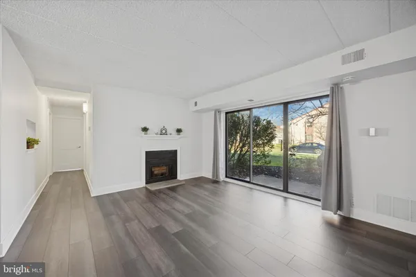 wooden floor fireplace and windows in an empty room