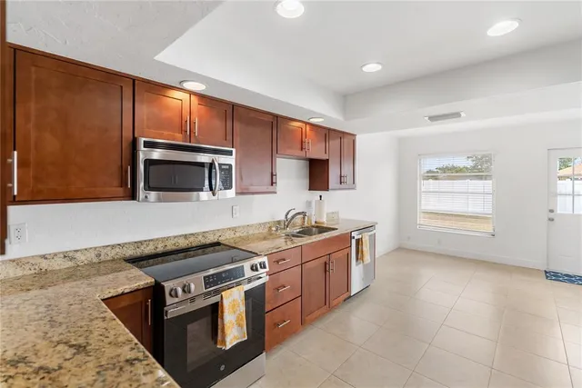 a kitchen with stainless steel appliances granite countertop a stove a sink and a microwave