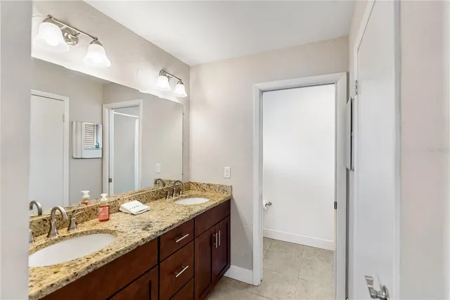 a bathroom with a granite countertop sink and a mirror