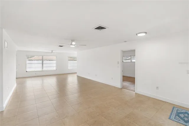 an empty room with chandelier and windows