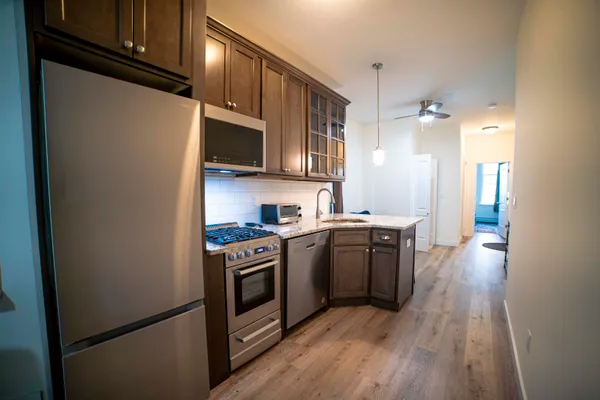 a kitchen with stainless steel appliances granite countertop a refrigerator a stove top oven a sink and dishwasher