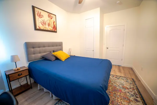 a bedroom with a bed and wooden floor
