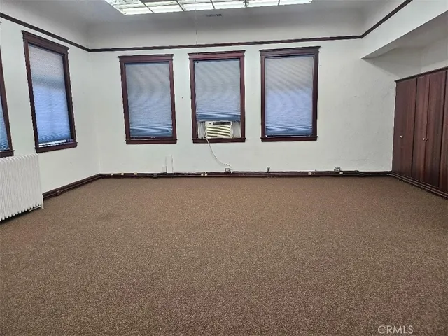 a view of a room with two windows and a ceiling fan