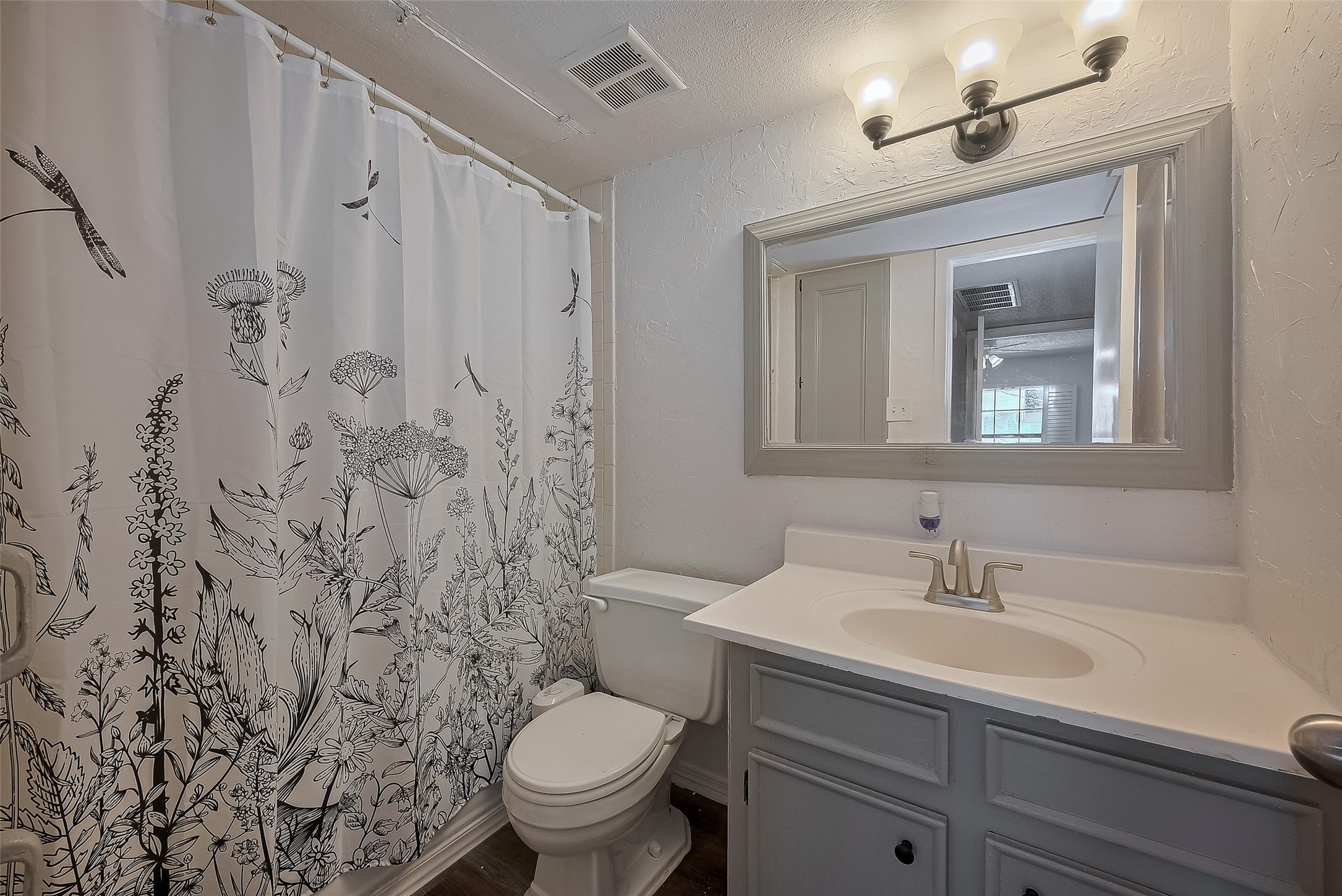 606 Marshall Street, Unit 35 Houston, TX 77006 - Photo 8 of 13 a bathroom with a sink a toilet and shower curtain