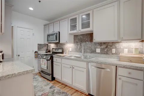 a kitchen with stainless steel appliances granite countertop a stove and a sink