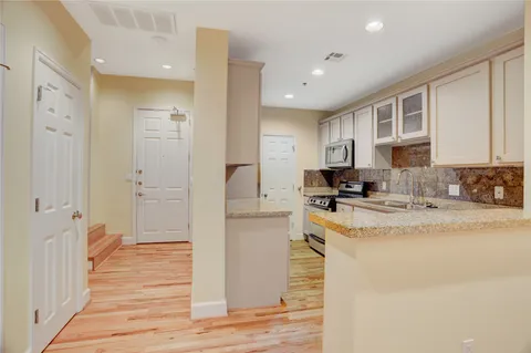 a large white kitchen with stainless steel appliances granite countertop a granite counter tops and a refrigerator