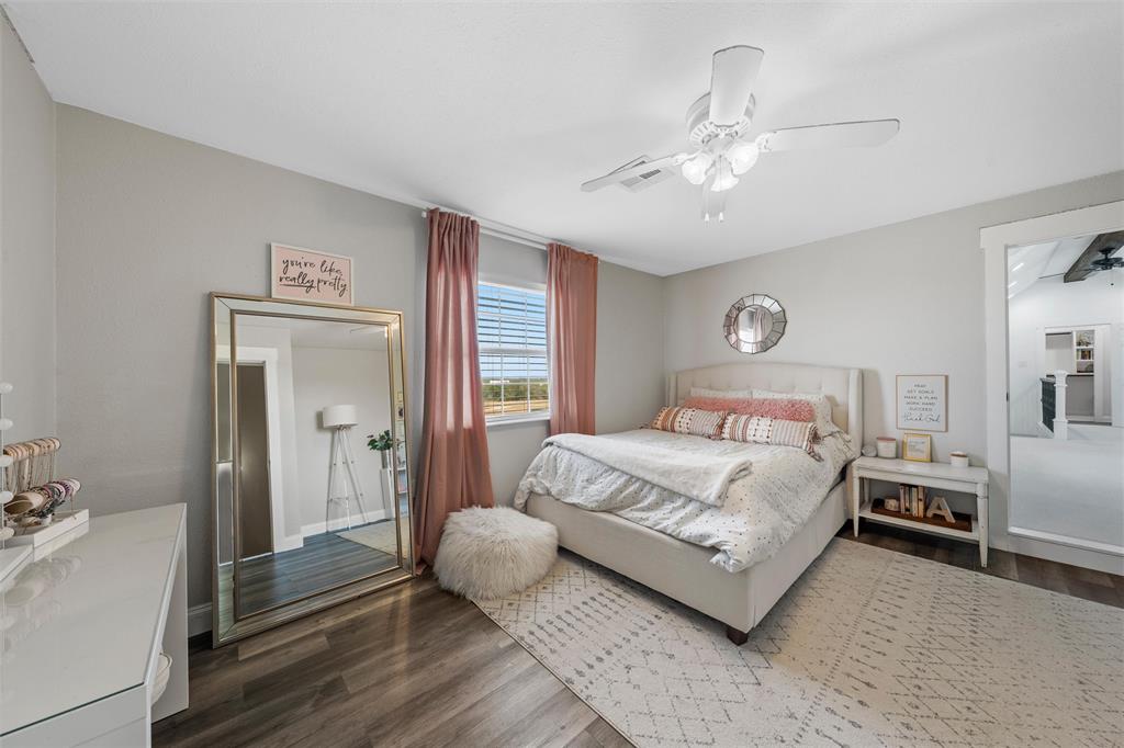 2045 Iron Bridge Road Lorena, TX 76655 - Photo 23 of 40 a bedroom with a large bed and a chandelier