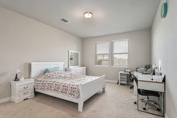 a bedroom with a bed and a table chair
