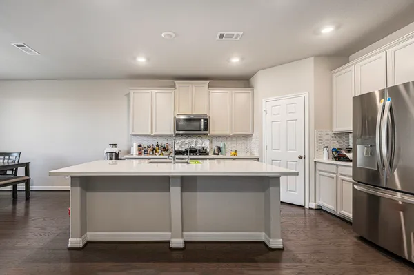 a kitchen with stainless steel appliances granite countertop a stove refrigerator and a microwave