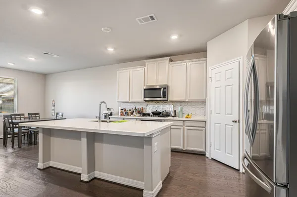 a kitchen with white cabinets and stainless steel appliances