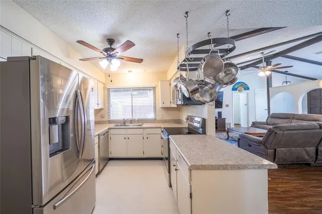 a kitchen with stainless steel appliances granite countertop a sink a stove and a refrigerator