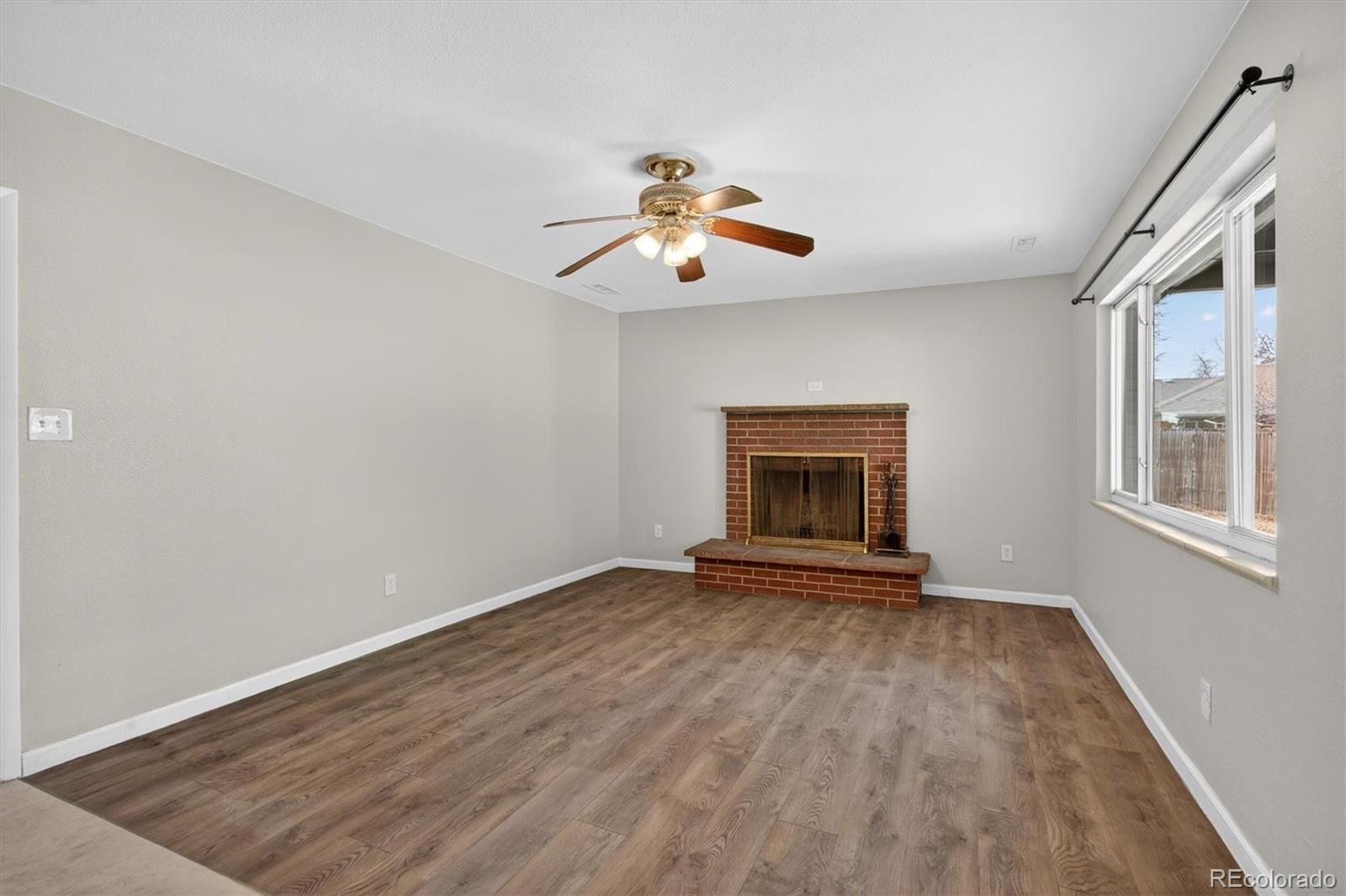 901 Racine Street Aurora, CO 80011 - Photo 11 of 29 a view of an empty room with window and chandelier fan