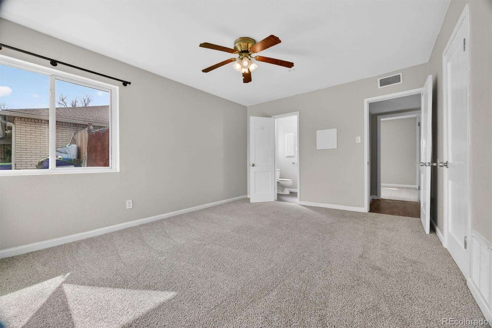901 Racine Street Aurora, CO 80011 - Photo 13 of 29 a view of an empty room with a ceiling fan and window