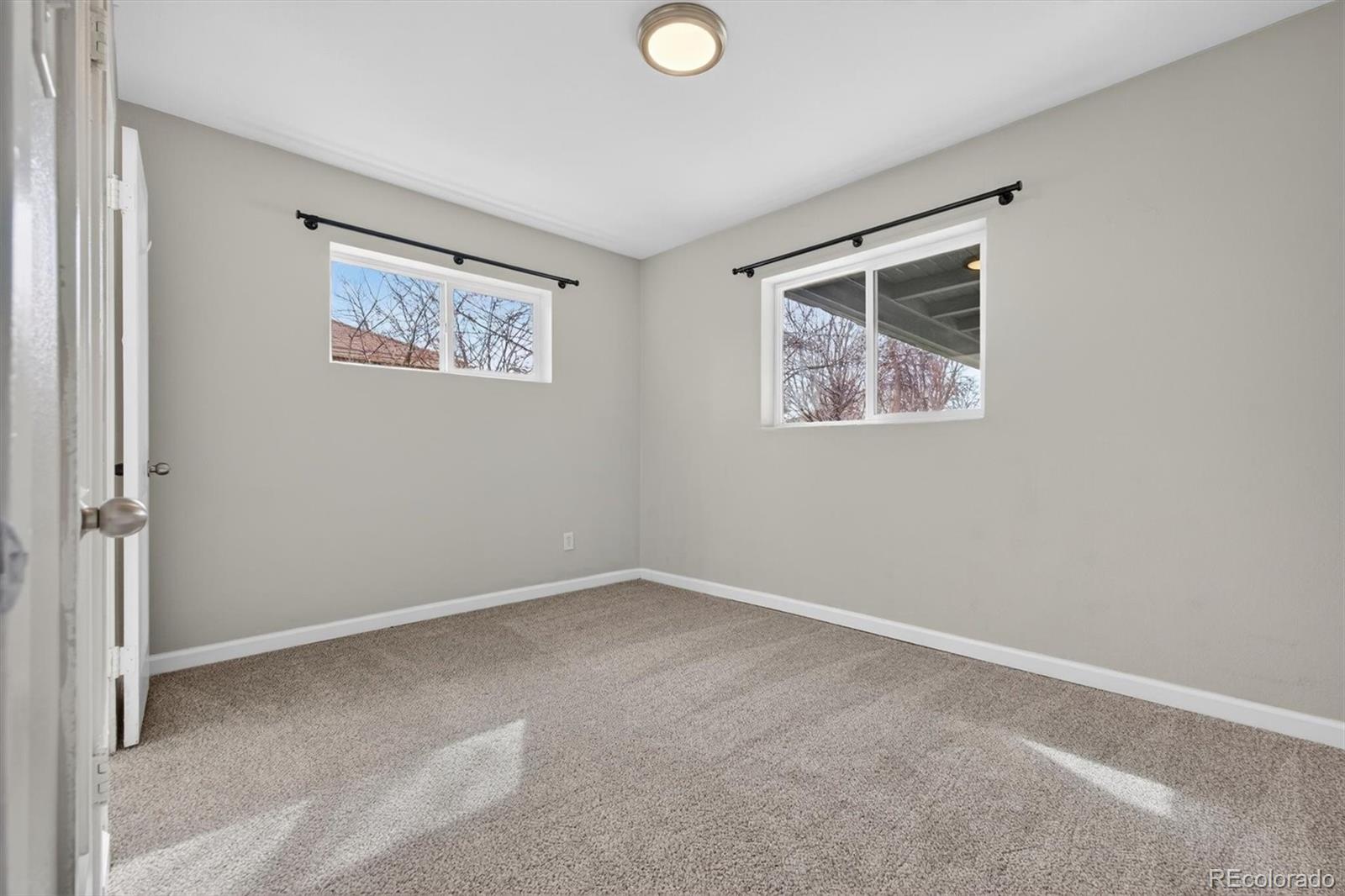901 Racine Street Aurora, CO 80011 - Photo 18 of 29 an empty room with a painting and a lamp