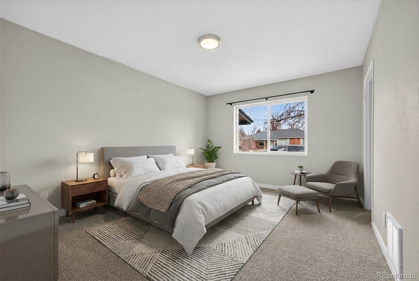 901 Racine Street Aurora, CO 80011 - Photo 20 of 29 a bed room with a bed and a chair