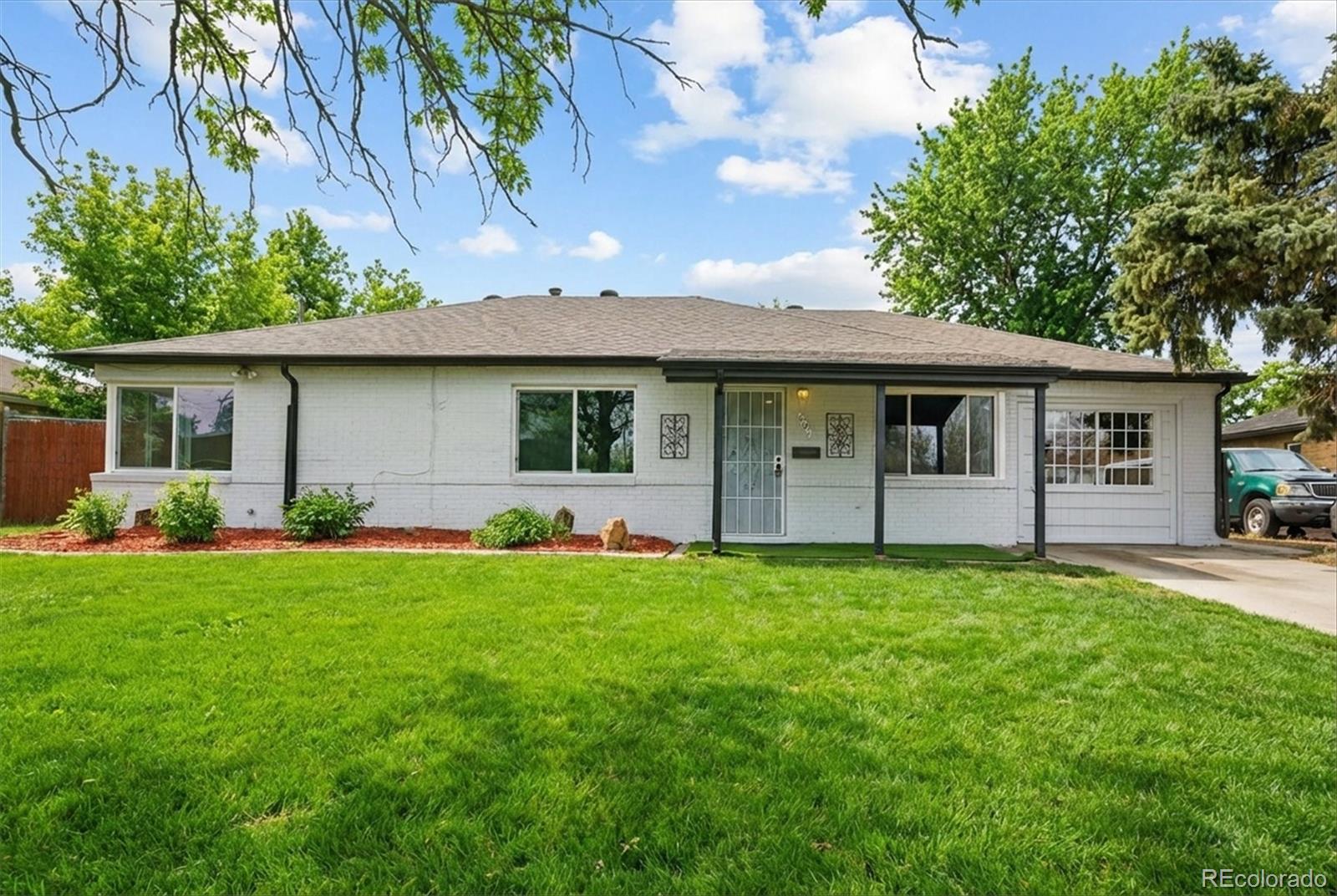 901 Racine Street Aurora, CO 80011 - Photo 2 of 29 a front view of house with yard and green space