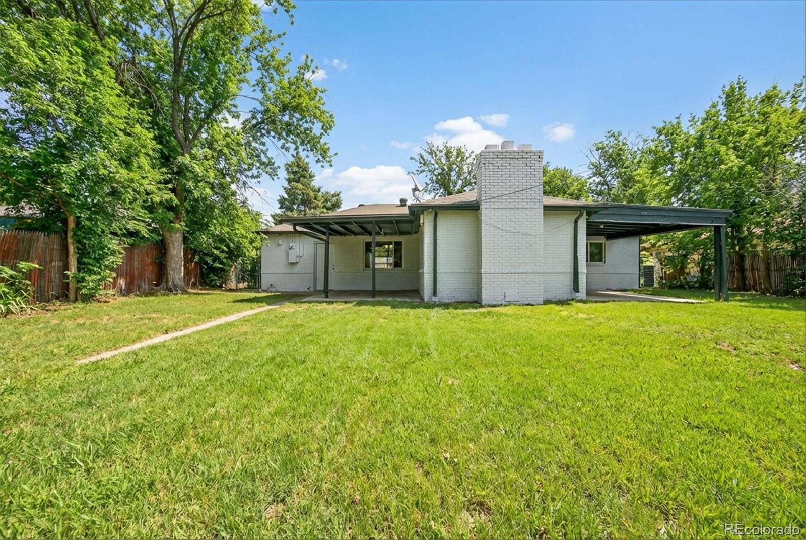 901 Racine Street Aurora, CO 80011 - Photo 25 of 29 a front view of a house with yard and garage