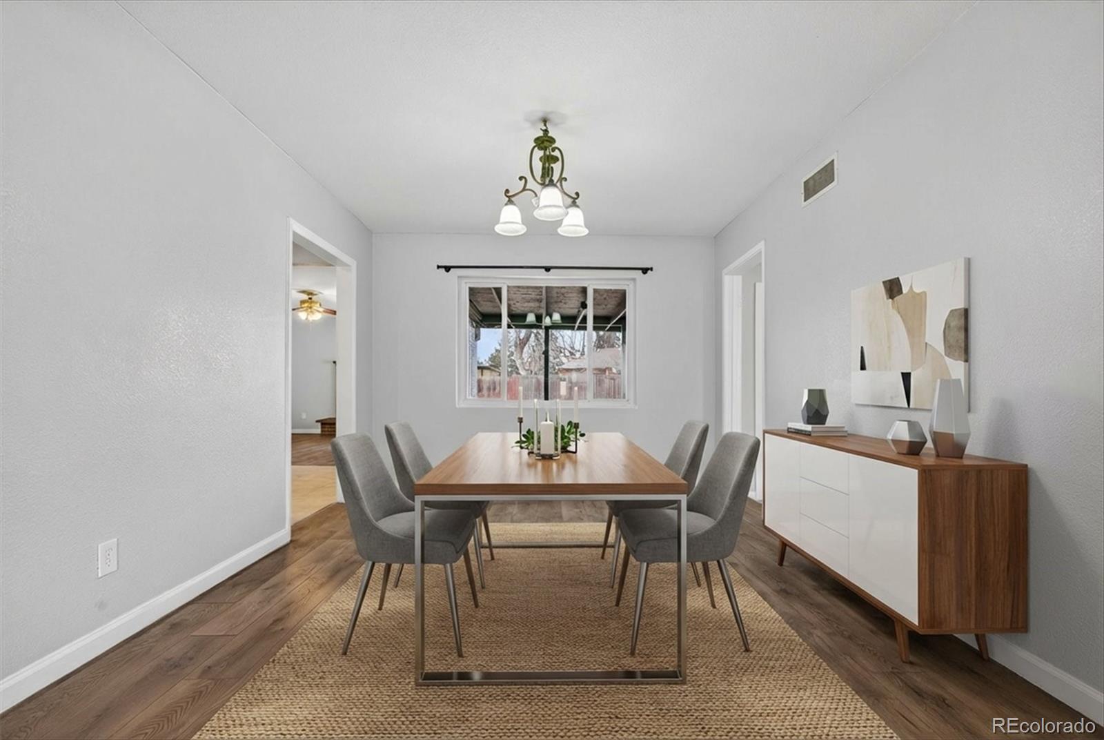 901 Racine Street Aurora, CO 80011 - Photo 28 of 29 a dining room with furniture a rug and a chandelier