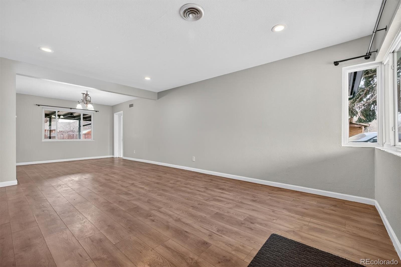 901 Racine Street Aurora, CO 80011 - Photo 4 of 29 a view of empty room with wooden floor and window