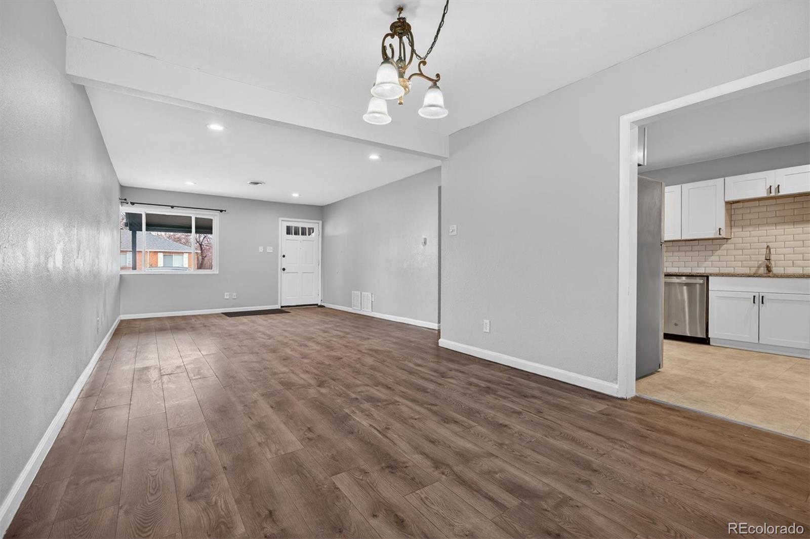 901 Racine Street Aurora, CO 80011 - Photo 6 of 29 a view of a kitchen with wooden floor and a kitchen space