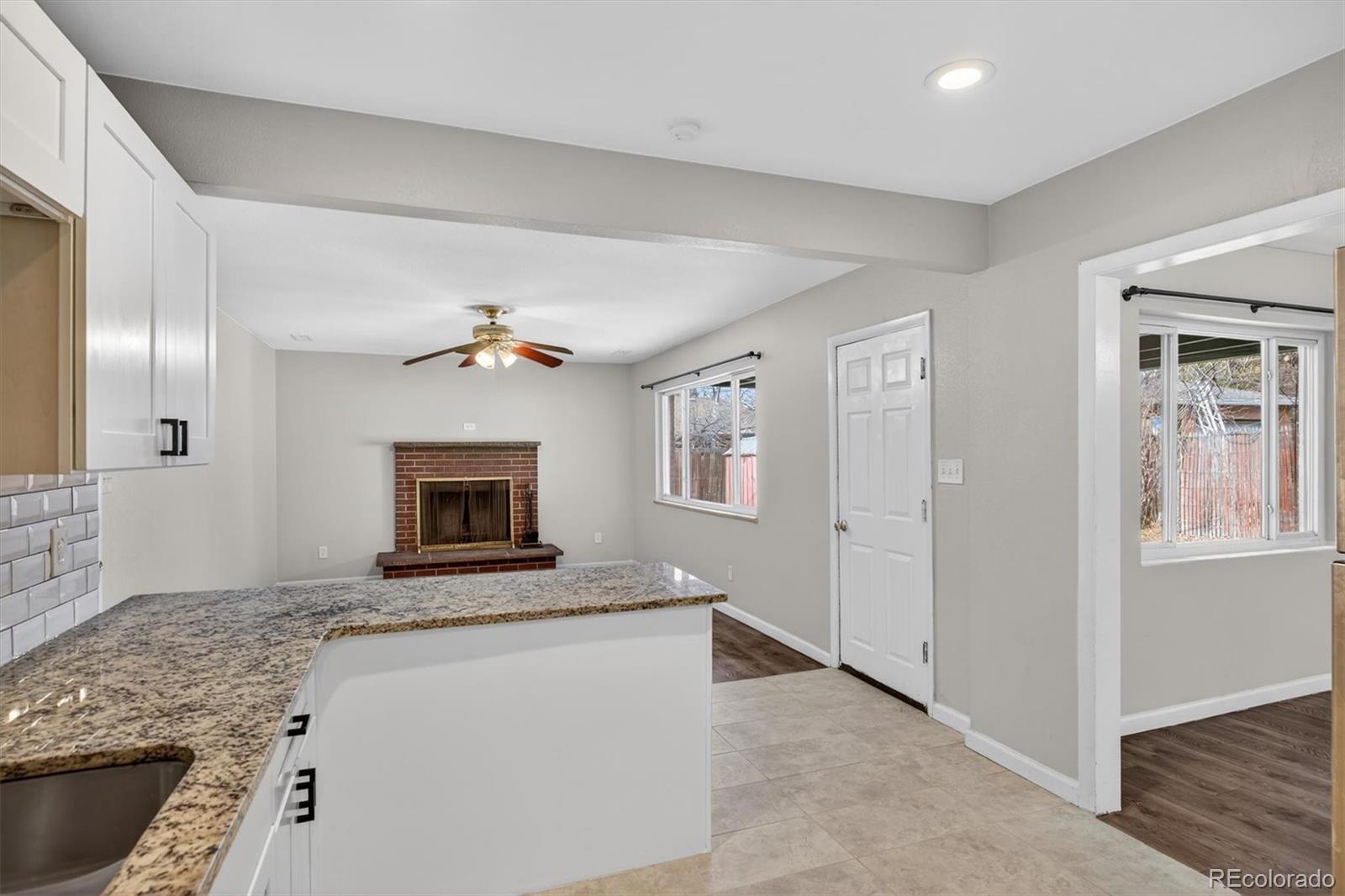 901 Racine Street Aurora, CO 80011 - Photo 9 of 29 a view of living room with granite countertop cabinets and fireplace