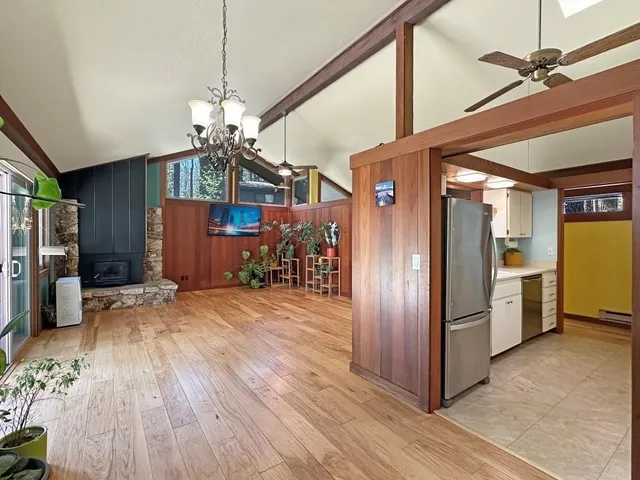 a view of a hallway with wooden floor and a kitchen