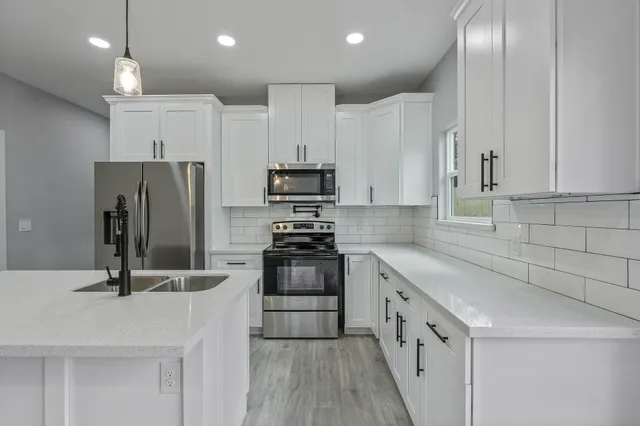 a kitchen with stainless steel appliances granite countertop a sink stove and refrigerator