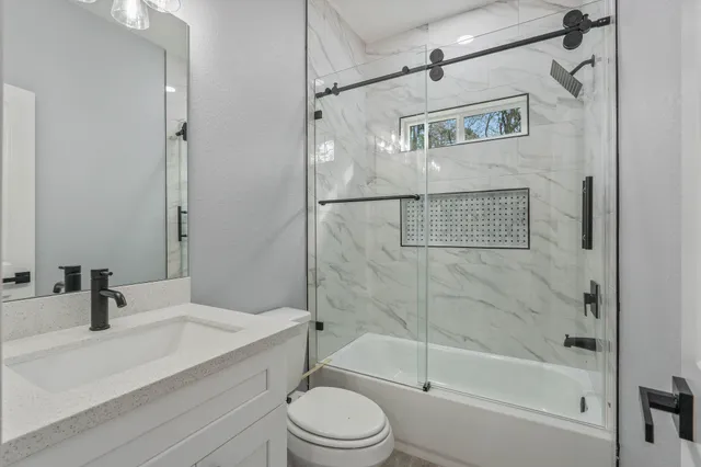 a bathroom with a sink a toilet and shower