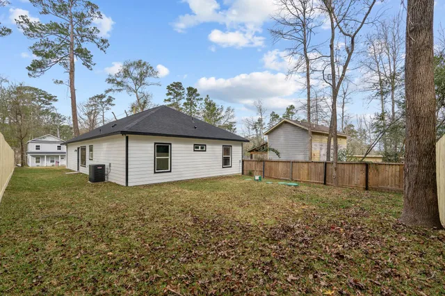 a view of a house with a yard and large tree