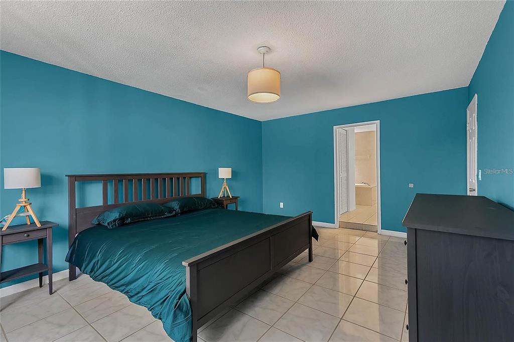 5607 Spring Run Avenue Orlando, FL 32819 - Photo 13 of 20 a bedroom with a bed and a book shelf