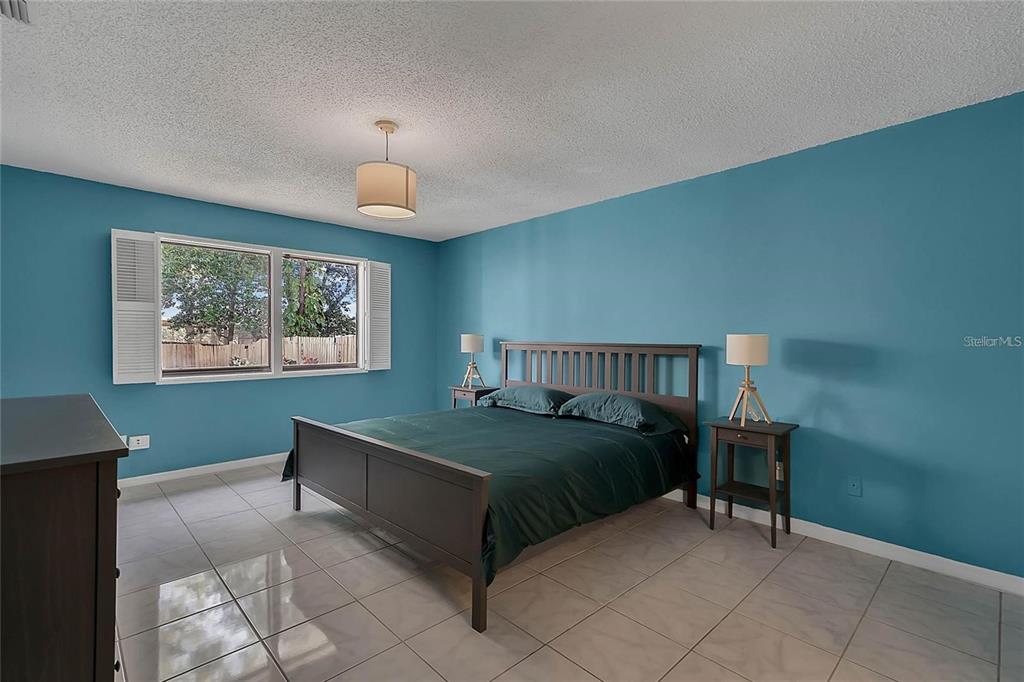 5607 Spring Run Avenue Orlando, FL 32819 - Photo 14 of 20 a bedroom with a bed and a chandelier