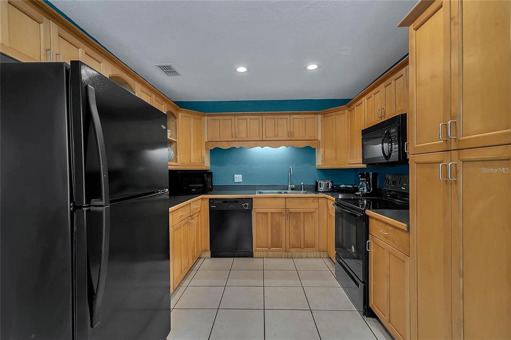 5607 Spring Run Avenue Orlando, FL 32819 - Photo 9 of 20 a kitchen with stainless steel appliances granite countertop a refrigerator and a stove